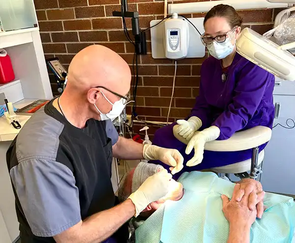 Why choose us Dr Feldner and assistant woring on patient
