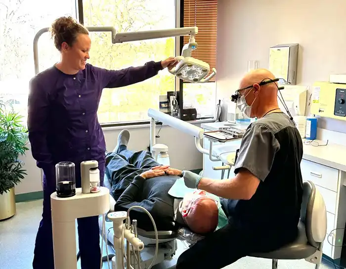 Why choose us Dr. Feldner and assistant standing over patient
